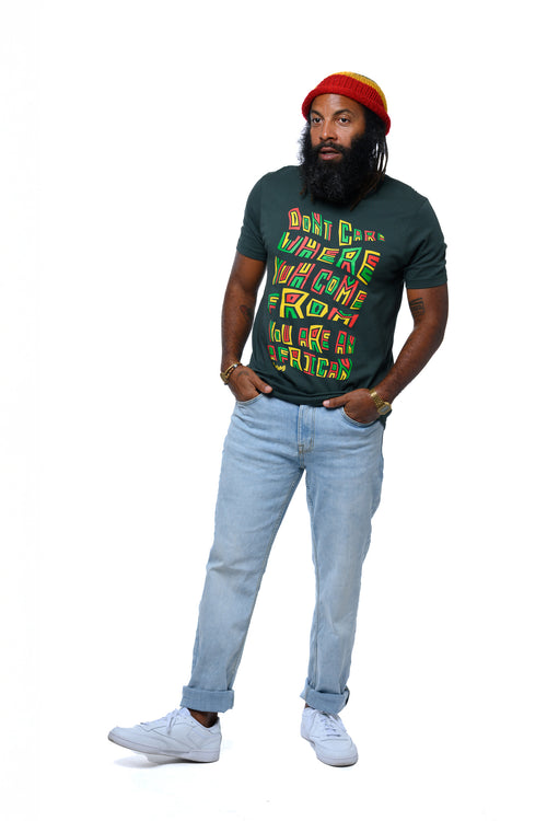Man wearing a colorful graphic t-shirt, with 'African' text, light blue jeans, and a red rasta beanie on a white background.  Cooyah, the offical reggae clothing brand since 1987.