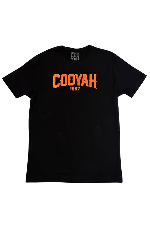 Black t-shirt with orange text 'COOYAH 1987' on a light gray background