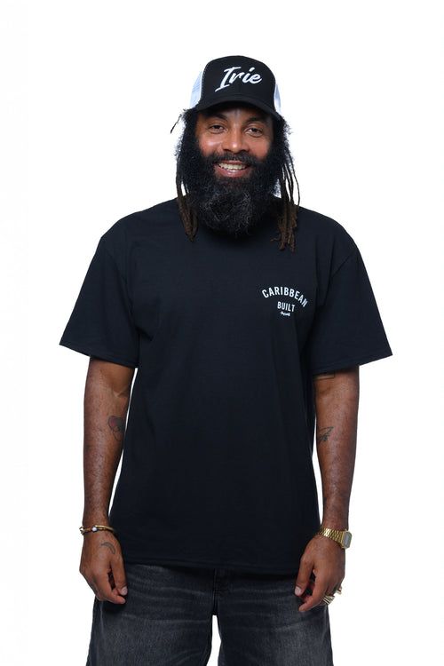 Man wearing a black t-shirt with text "Caribbean Built" and a cap with embroidered text "Irie"  on a white background