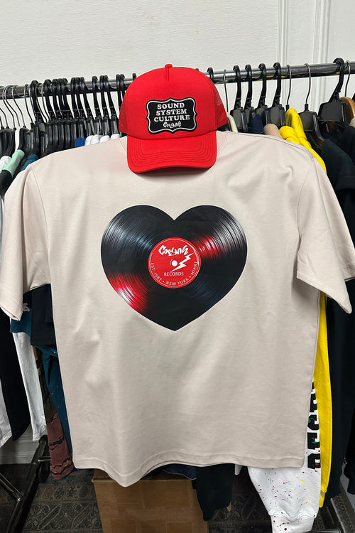 Cooyah men's heart shaped vinyl graphic tee printed on a boxy style sand colored shirt. Paired with a Sound System Culture Hat.