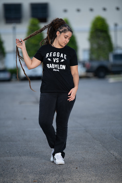 Cooyah Women's Reggae VS Babylon graphic tee.  As a Jamaican owned clothing brand since 1987, we take pride in bringing you this classic piece. Don't wait, get yours now!