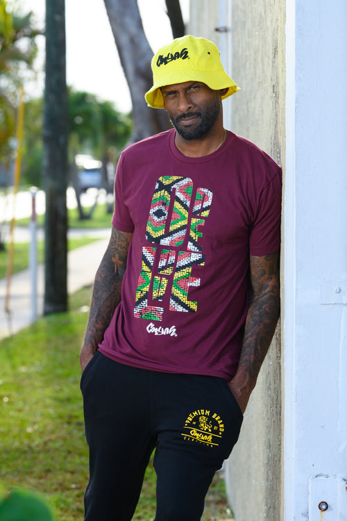 Cooyah Jamaica. One Love Africa Print graphic tee. Men's short sleeve, ringspun cotton tee in burgundy. Jamaican clothing brand.