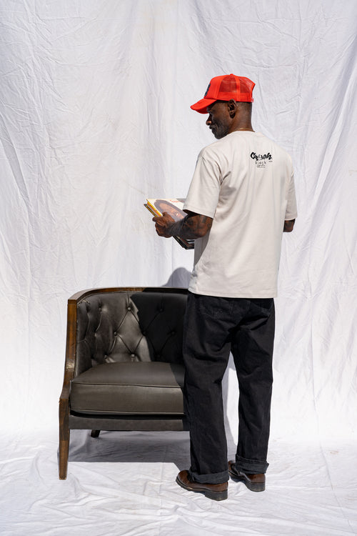 Back view of the Cooyah men's heart shaped vinyl graphic tee printed on a boxy style sand colored shirt. Paired with a Reggae Massive hat in red.