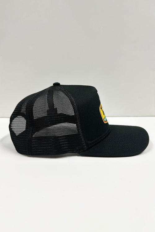 Side profile of black and yellow Made in Jamaica Trucker Hat with curved bill.