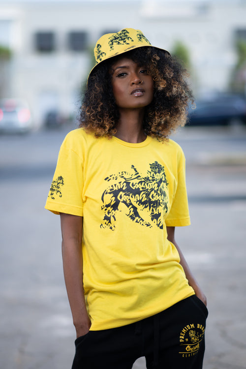 Cooyah rasta lion graphic tee. Women's yellow t-shirt with black lion graphics screen printed on the front and sleeves. Jamaican reggae clothing brand since 1987. IRIE