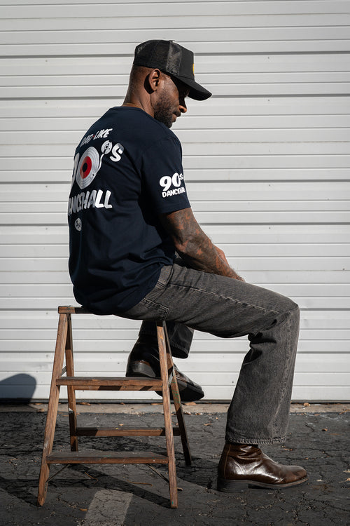 Model wearing Cooyah Bad Like 90s Dancehall graphic t-shirt, side profile showing classic reggae streetwear fit. Cooyah Clothing Brand.