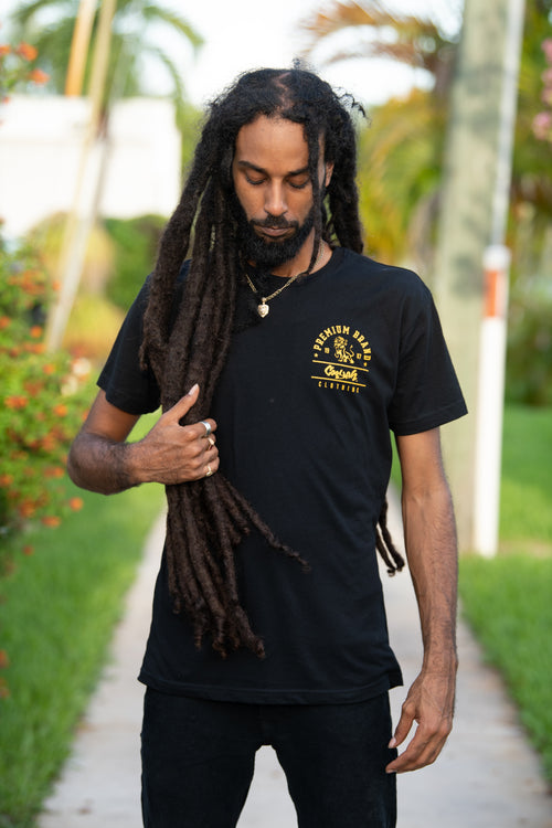 Cooyah Jamaica. Men's Premium Brand graphic tee. Gold Lion design screen printed on a black ringspun cotton t-shirt. Jamaican streetwear clothing brand.