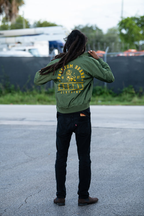 Cooyah Clothing - Men's Premium Brand Bomber Jacket with gold Lion print on olive green fabric. We are a Jamaican streetwear clothing brand established in 1987.