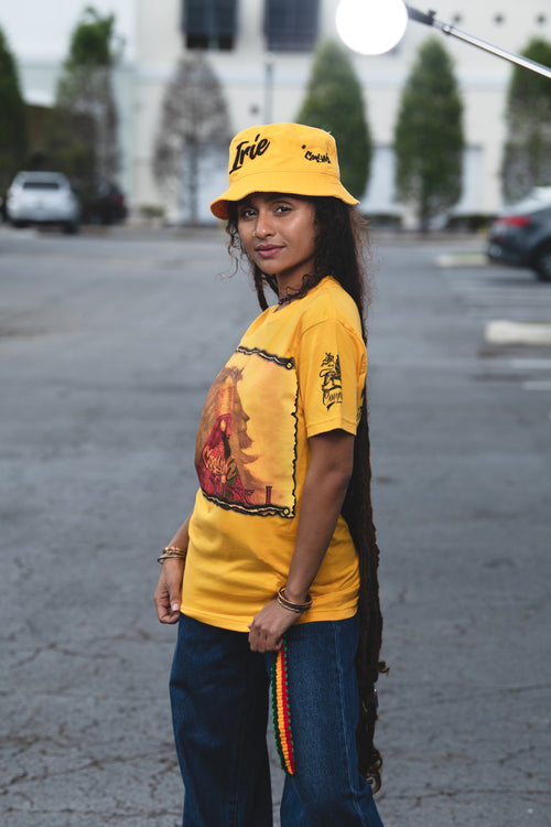Cooyah Clothing - Women's Haile Selassie Rastafari Lion graphic tee in gold. Crew neck, short sleeve, soft, ringspun cotton. As a Jamaican owned clothing brand since 1987, we take pride in bringing you this classic rasta shirt.