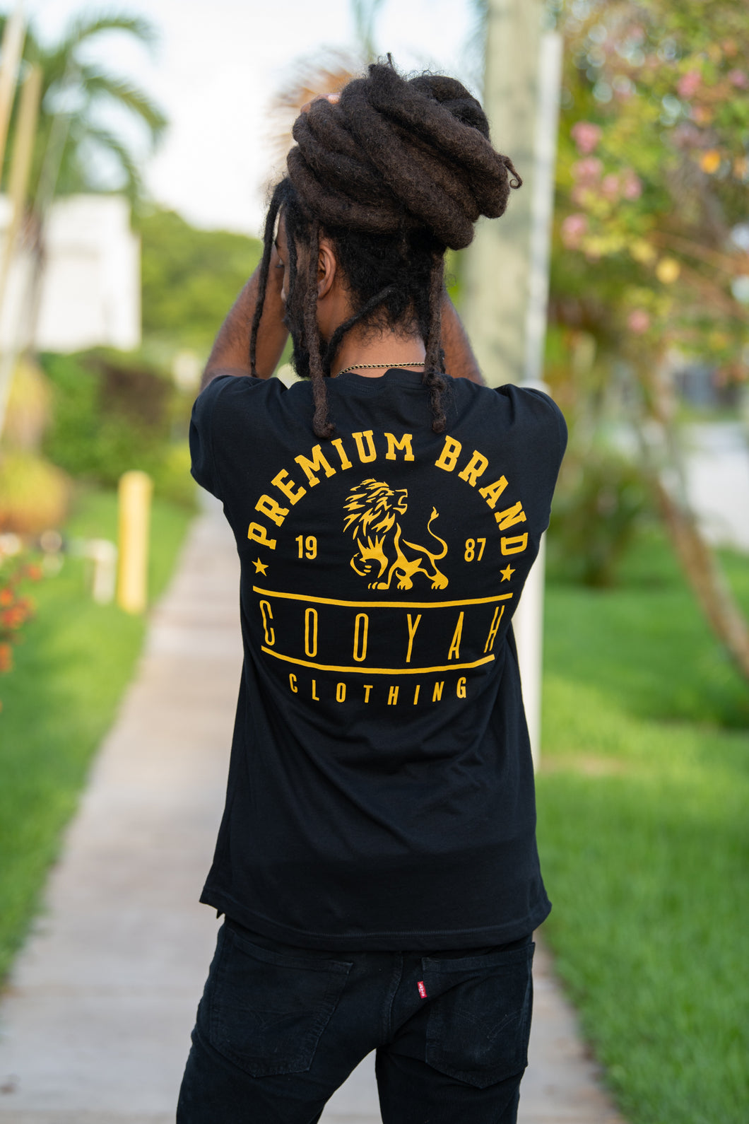 Cooyah Jamaica. Men's Premium Brand graphic tee. Gold Lion design screen printed on a black ringspun cotton t-shirt. Jamaican streetwear clothing brand.