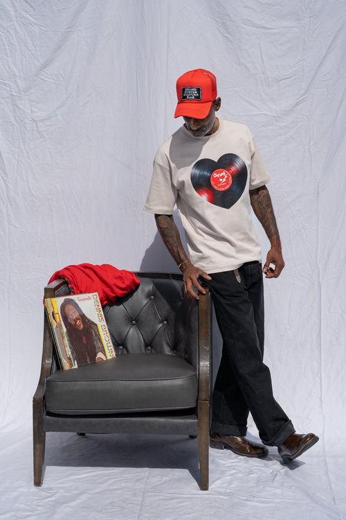 Cooyah men's heart shaped vinyl graphic tee printed on a boxy style sand colored shirt.  Paired with a Reggae Massive cap.