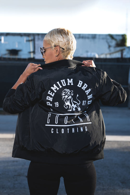 Cooyah Jamaica, Women's Premium Brand Bomber Jacket with Lion graphic in black. Jamaican streetwear clothing.