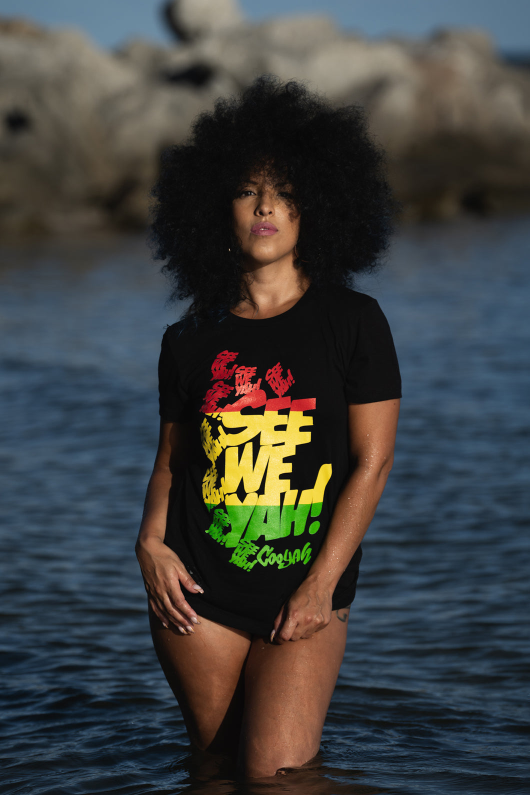 Cooyah Jamaica.  Women's black graphic tee with See We Yah Jamaican patois graphics in reggae colors.  Short sleeve, crew neck, ringspun cotton.