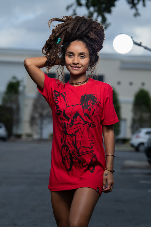 Cooyah Jamaica. Women's relaxed fit Simmer Down T-Shirt featuring a Rastaman on a bicycle design. Ring Spun Cotton, Short Sleeve Red Tee. Jamaican streetwear clothing brand.