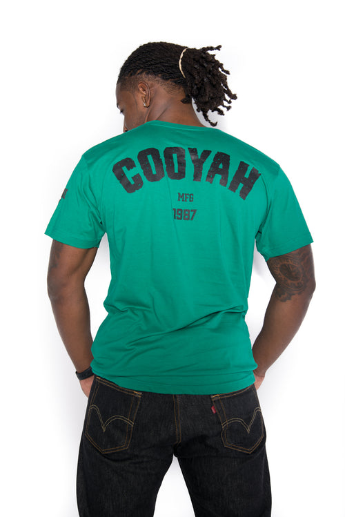 Cooyah men's graphic tee available in green. We are a Jamaican owned clothing brand established in 1987.