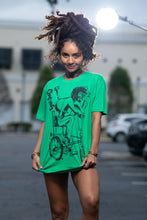 Load image into Gallery viewer, Cooyah Jamaica. Women&#39;s relaxed fit Simmer Down T-Shirt featuring a Rastaman on a bicycle design. Ring Spun Cotton, Short Sleeve green Tee. Jamaican streetwear clothing brand.
