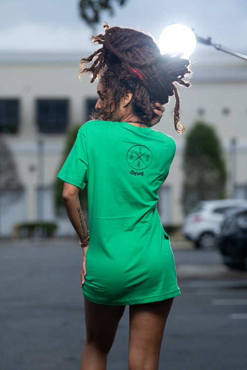 Cooyah Jamaica. Women's relaxed fit Simmer Down T-Shirt featuring a Rastaman on a bicycle design. Ring Spun Cotton, Short Sleeve green Tee. Jamaican streetwear clothing brand.