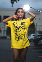Load image into Gallery viewer, Cooyah Jamaica. Women&#39;s relaxed fit Simmer Down T-Shirt featuring a Rastaman on a bicycle design. Ring Spun Cotton, Short Sleeve yellow Tee. Jamaican streetwear clothing brand.
